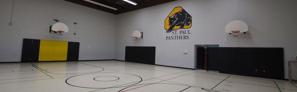 St. Paul Catholic School gym, their logo of a black panther painted on the wall above basketball nets. 